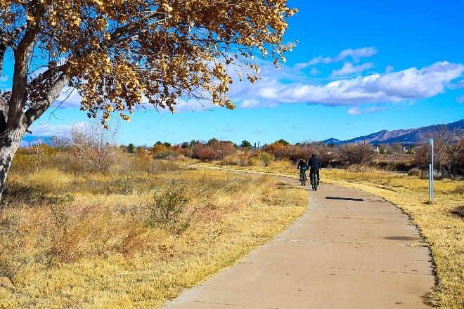 Two people on bikes along trail in the fall