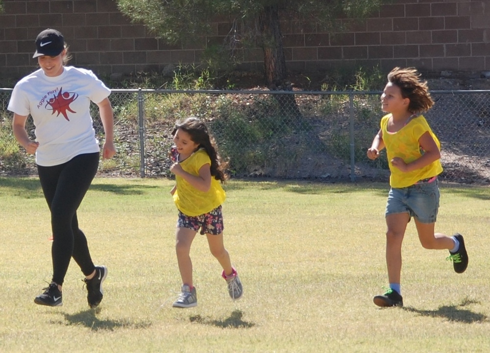 Female college athletes work with school age students to stay active